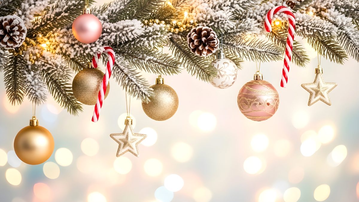 Christmas tree branches decorated with golden ornaments and candy canes with bokeh background stock photo