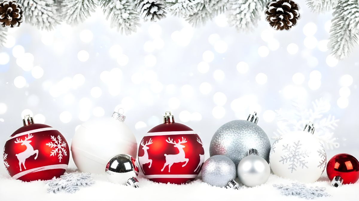 Christmas ornaments with reindeer and snowflakes on snow with pine branches background stock photo