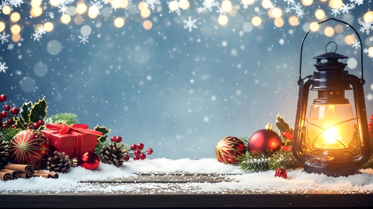 Glowing vintage lantern with christmas decorations on snowy wooden table for holiday background stock photo