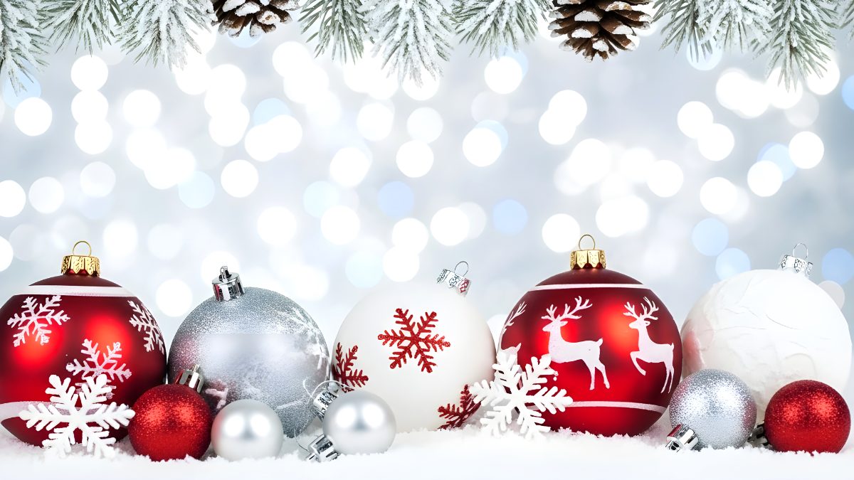 Christmas ornaments background with red and silver baubles on snow with pine branches and bokeh stock photo