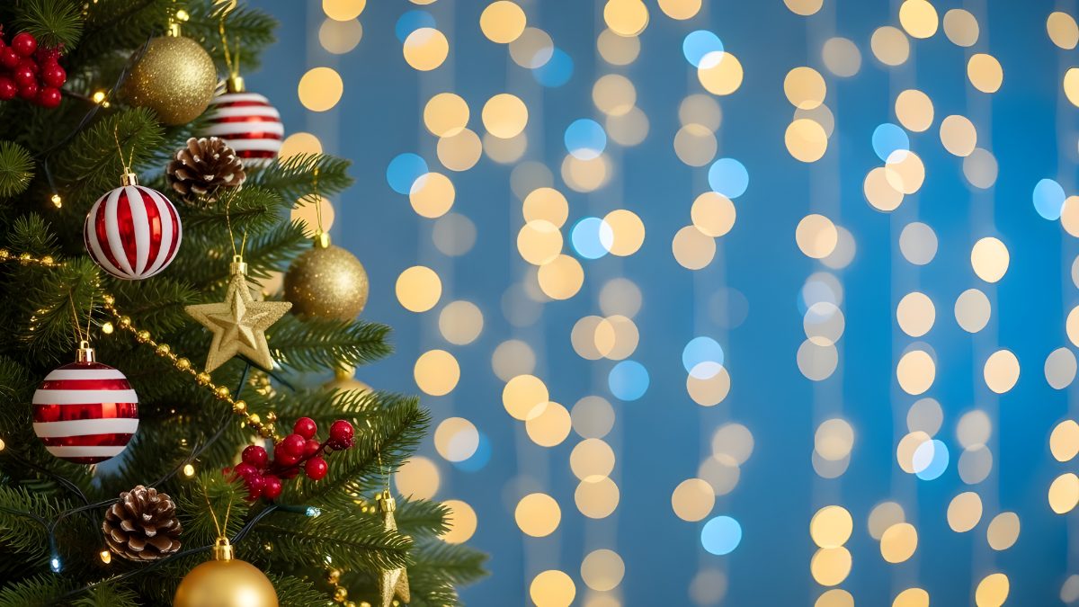Decorated christmas tree with ornaments and golden bokeh lights on blue background stock photo